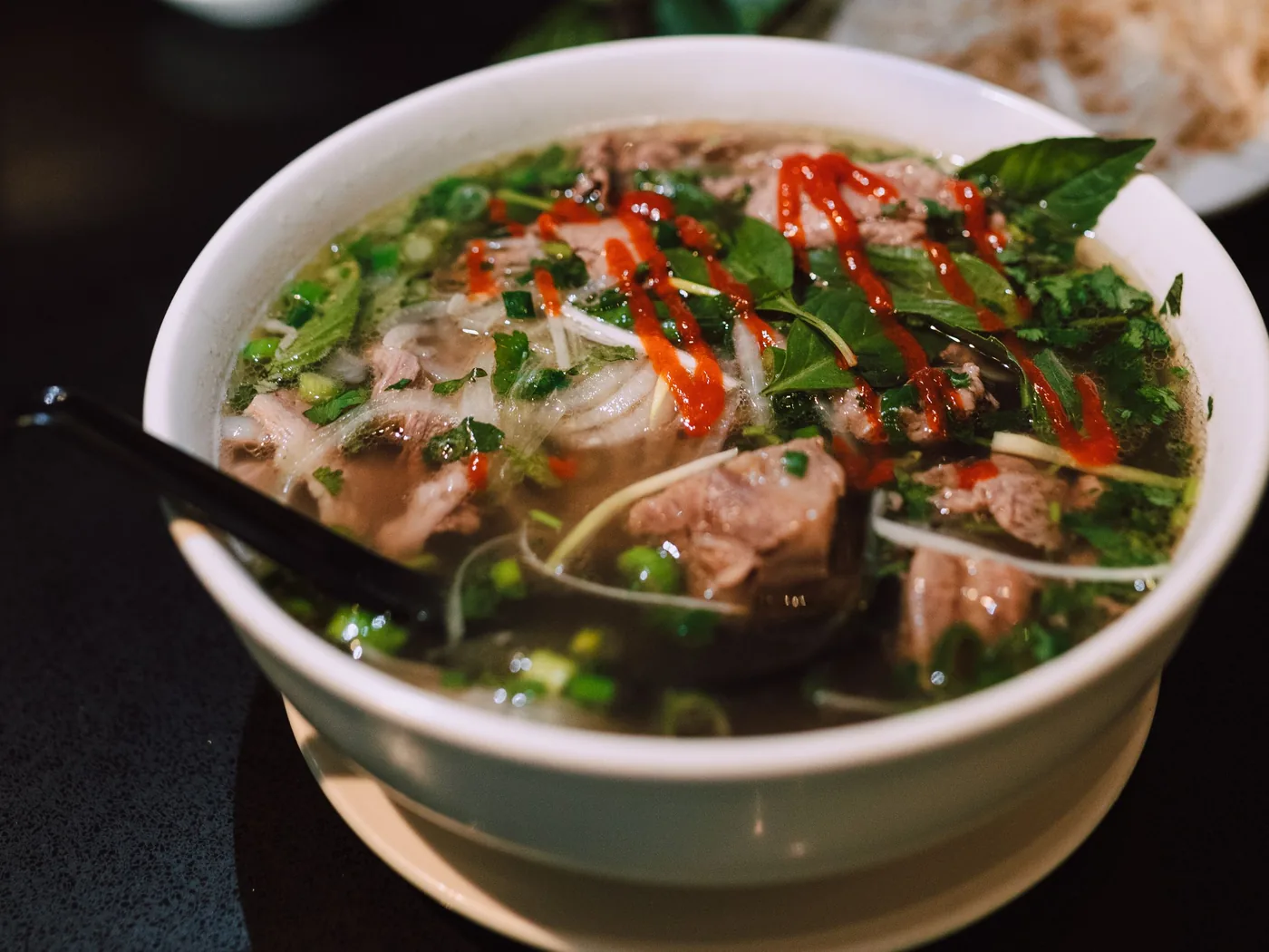 Una fumante ciotola di pho vietnamita con erbe aromatiche