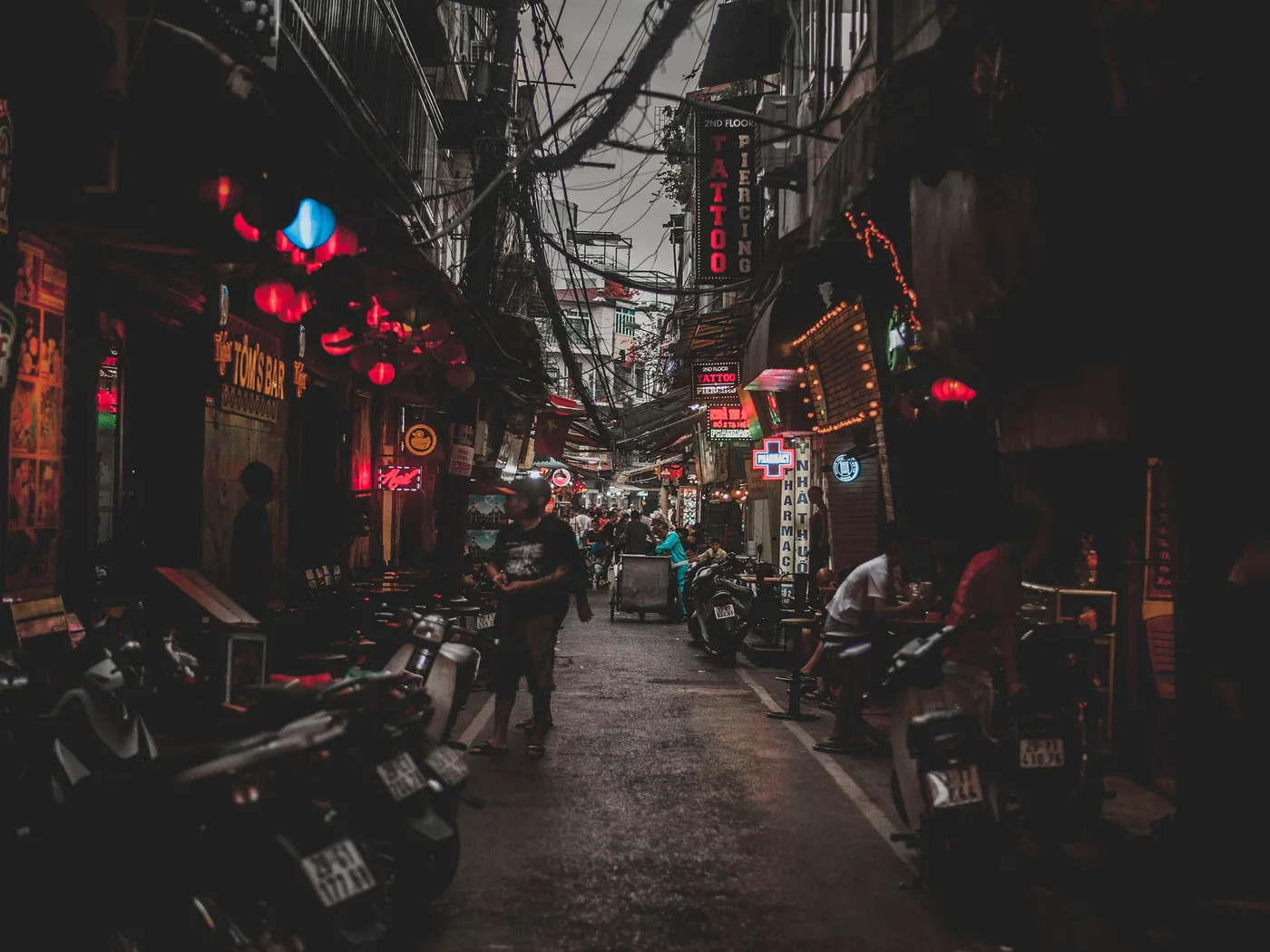 Una affollata strada del Quartiere Vecchio di Hanoi di notte, con bancarelle di cibo